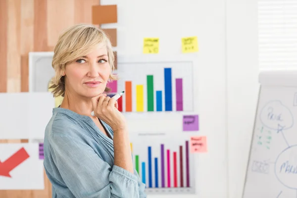 Thoughtful businesswoman writing on a white board — Stock Photo, Image