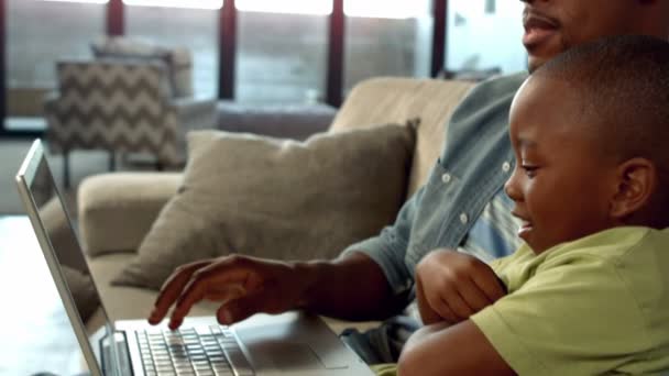 Ojciec i syn korzysta z laptopa na kanapie — Wideo stockowe
