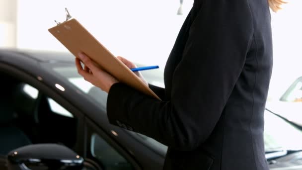Affärskvinna checkar ut en bil — Stockvideo