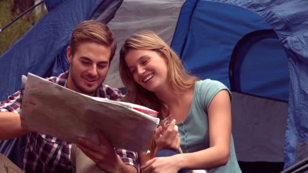 Couple looking at map in their tent — Stock Video