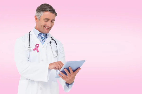 Composite image of happy doctor using tablet pc — Stock Photo, Image