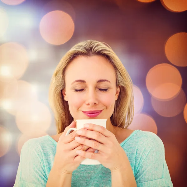 Alegre loira segurando caneca de bebida quente — Fotografia de Stock