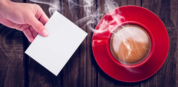 Bovenaanzicht van hete thee door hand met pagina — Stockfoto