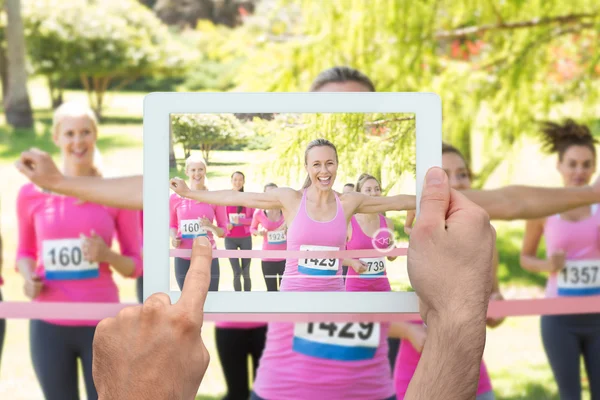 Imagen compuesta de la mano que sostiene la tableta pc — Foto de Stock