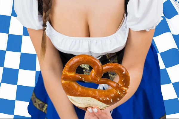 Oktoberfest flicka bockning och visar kringla — Stockfoto