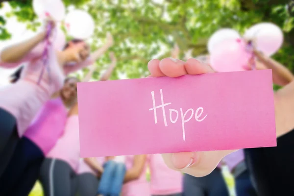 Hoffnung gegen lächelnde Frauen in Rosa — Stockfoto