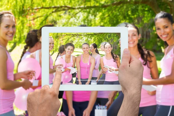 Imagem composta de mão segurando tablet pc — Fotografia de Stock