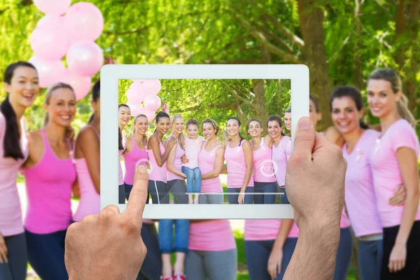 Imagen compuesta de la mano que sostiene la tableta pc — Foto de Stock