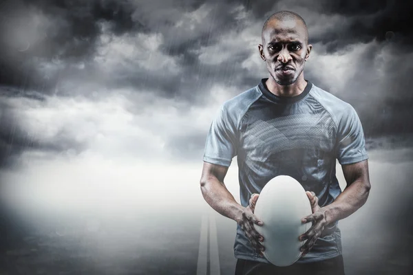 Atleta serio sosteniendo pelota de rugby —  Fotos de Stock