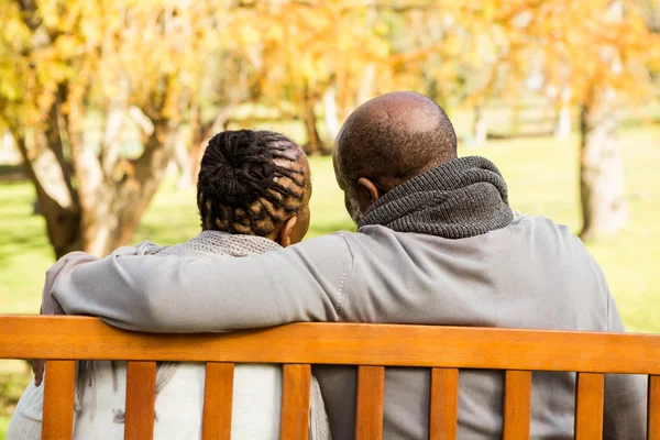 Счастливая старшая пара, обсуждающая вместе на скамейке — стоковое фото