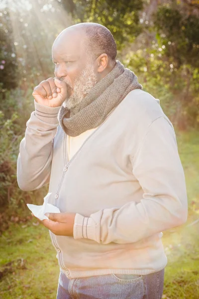 Senior man hoesten met weefsel — Stockfoto