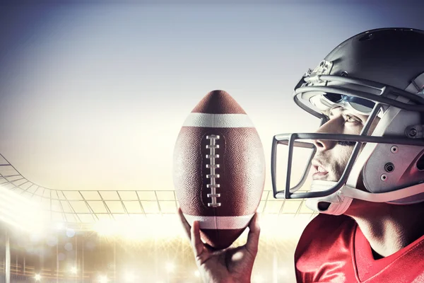 Sportsman looking up while holding American football — Stock Photo, Image