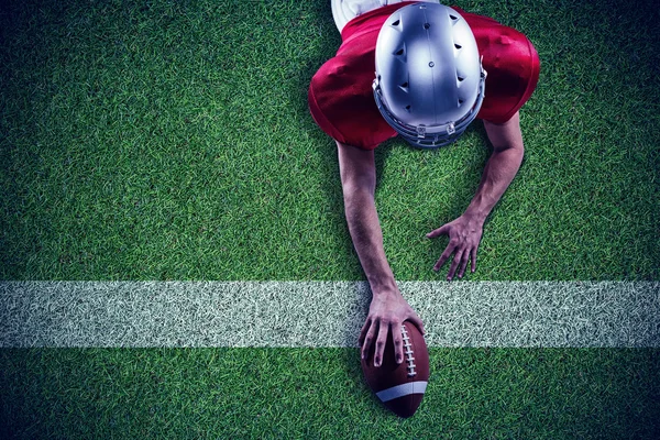 Американський футбол player лежачи на поле — стокове фото