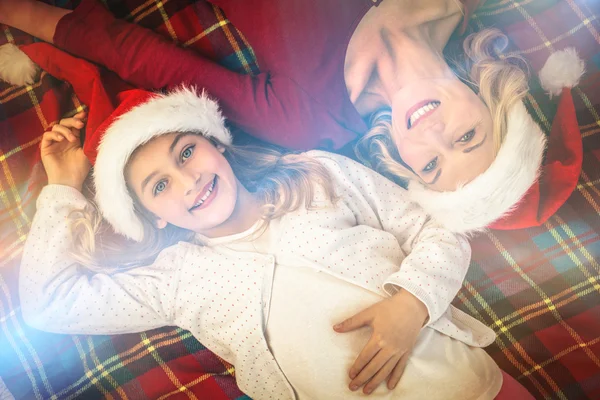 Festive mother and daughter smiling at camera on blanket — Stock Photo, Image