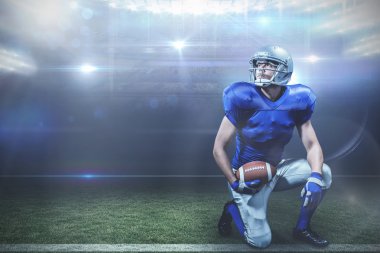 American football player with ball kneeling clipart
