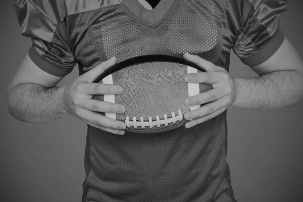 American Football-Spieler hält einen Ball — Stockfoto