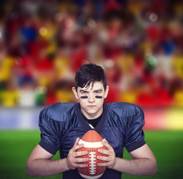 Jogador de futebol americano determinado segurando uma bola — Fotografia de Stock