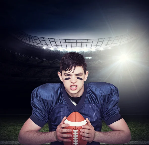Enfurecido jogador de futebol americano segurando uma bola — Fotografia de Stock