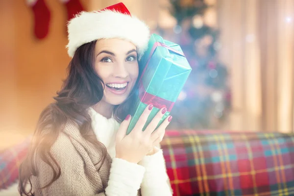 Festliche Brünette hält Geschenk zu Weihnachten — Stockfoto
