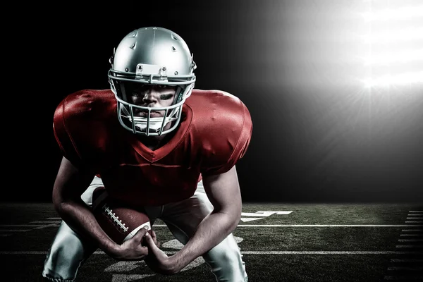 American football player bending while holding ball — Stock Photo, Image