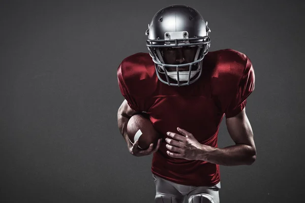 Imagem composta de jogador de futebol americano correndo com bola — Fotografia de Stock