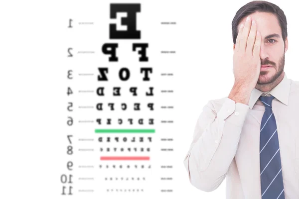 Unsmiling patient against eye test — Stock Photo, Image