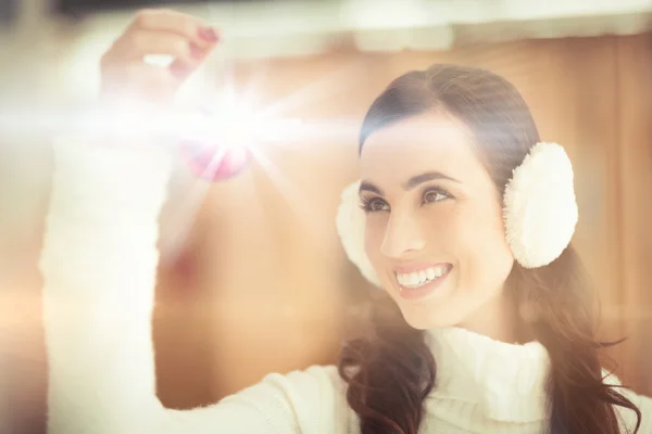 Bonita morena con orejeras sosteniendo chucherías — Foto de Stock