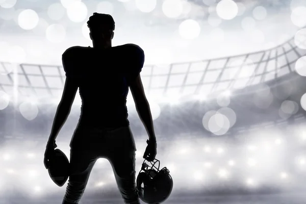 Jogador de futebol americano segurando bola e capacete — Fotografia de Stock