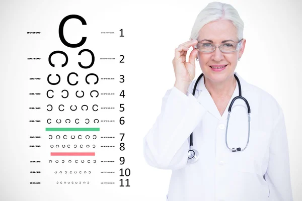 Улыбающаяся женщина-врач против теста на зрение — стоковое фото