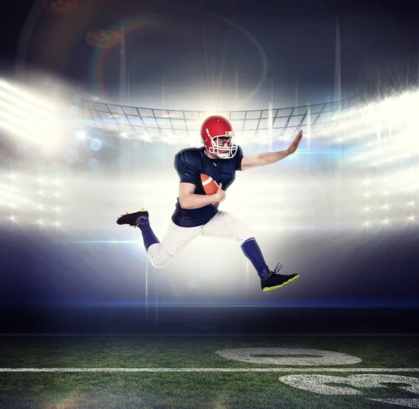 American football speler springen met de bal — Stockfoto