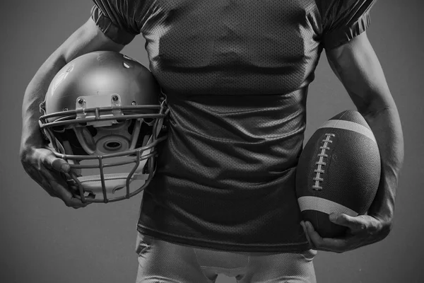 American football player holding helmet and ball — Stock Photo, Image