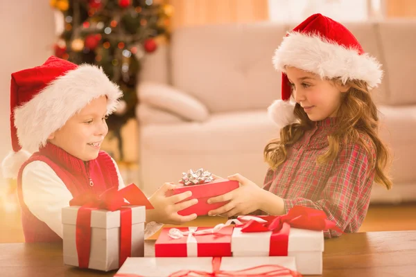 Feestelijke broers en zussen glimlachen op hun giften — Stockfoto