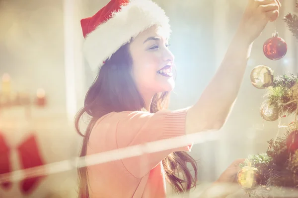 Morena feliz decorando uma árvore de Natal — Fotografia de Stock