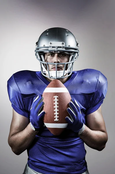 Confident American football player holding ball — Stock Photo, Image