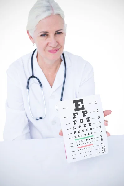 Female doctor showing notepad against eye test — Stock Photo, Image