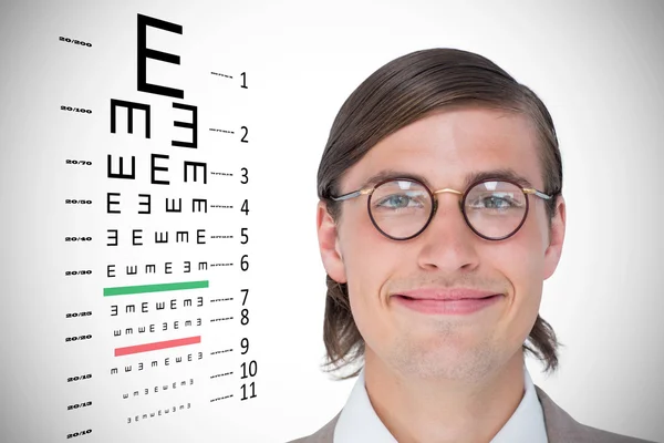 Hipster looking at camera against eye test — стоковое фото