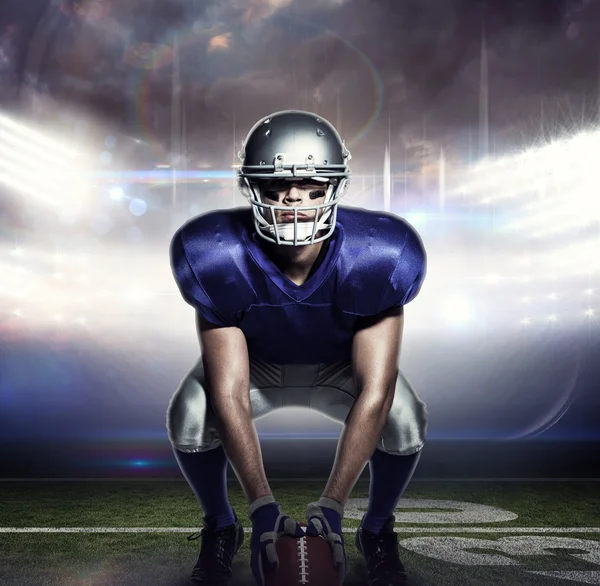 Samengestelde afbeelding van Amerikaans football-speler met bal crouching — Stockfoto