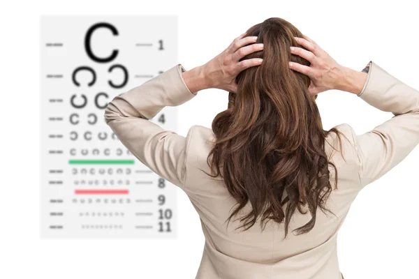 Business woman with hands on head against eye test — стоковое фото