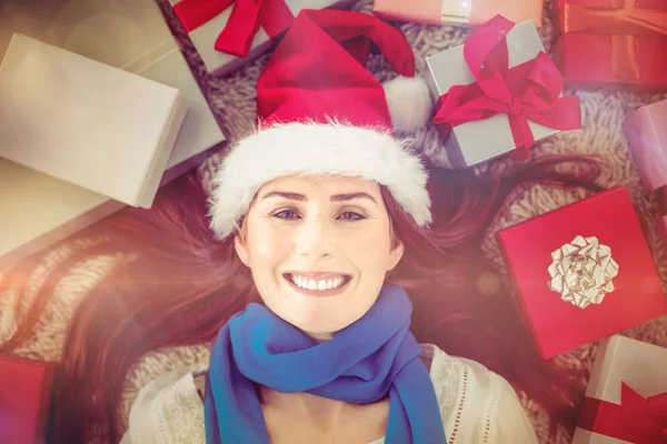 Festive redhead smiling at camera with gifts — Stock Photo, Image