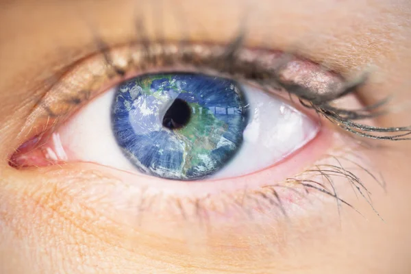 Ojo azul femenino contra la tierra — Foto de Stock