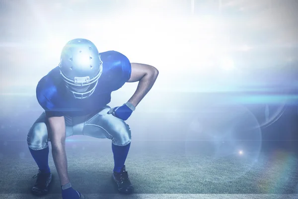 American football speler in uniforme buigen — Stockfoto