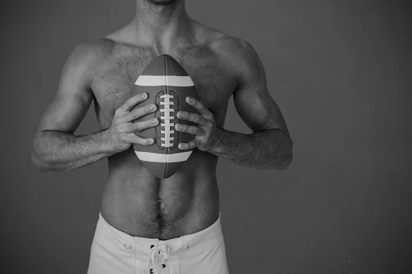 Shirtless rugby player holding ball — Stock Photo, Image