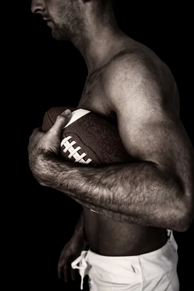 Игрок в регби без рубашки держит мяч — стоковое фото
