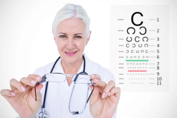 Óptico femenino que presenta anteojos contra la prueba ocular — Foto de Stock