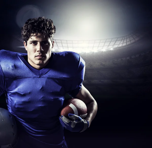 ヘルメットとボールを保持している深刻なアメリカン ・ フットボール プレーヤー — ストック写真