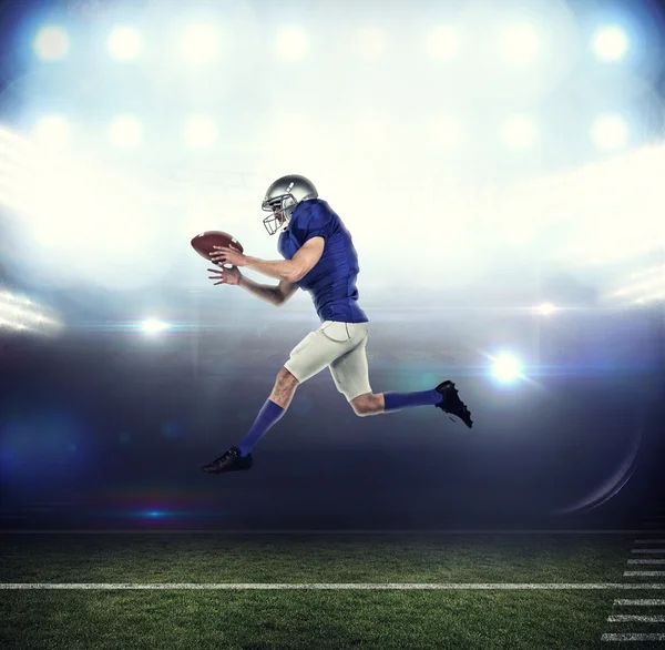 Jugador de fútbol americano corriendo mientras captura la pelota — Foto de Stock