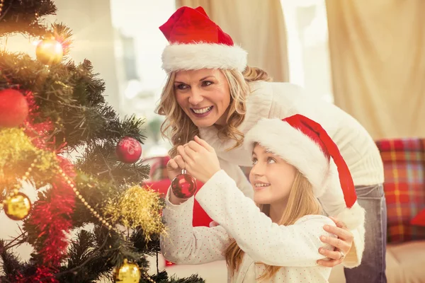 Festive mother and daughter decorating christmas tree — Stock Photo, Image