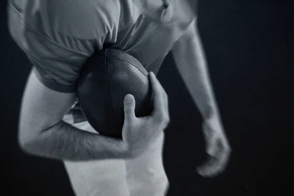 Jugadora de fútbol americano tomando una pelota en su mano — Foto de Stock