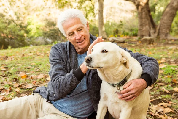 Äldre man med sin hund i park — Stockfoto