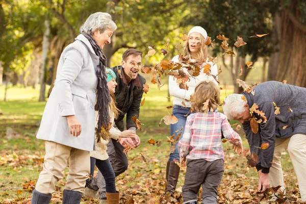 Ευτυχισμένη οικογένεια εκτεταμένη ρίψη φύλλα γύρω από — Φωτογραφία Αρχείου